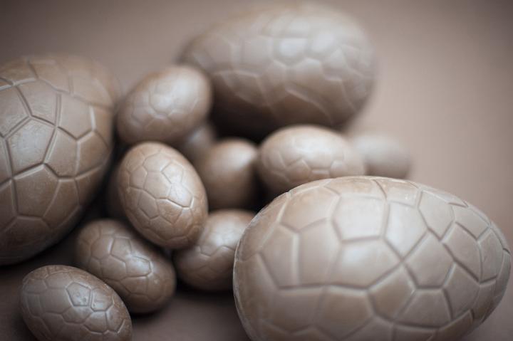 assorted_easter_eggs.jpg - Assorted sizes of chocolate Easter Eggs on a brown background with shallow depth of field