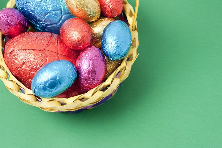 easter_copyspace.jpg - Overhead corner view of an Easter Egg basket filled with colourful foil wrapped eggs with copyspace