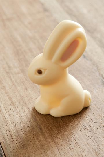 choc_easter_bunny.jpg - A single little white milk chocolate Easter bunny egg viewed high angle on wood to celebrate the holiday season