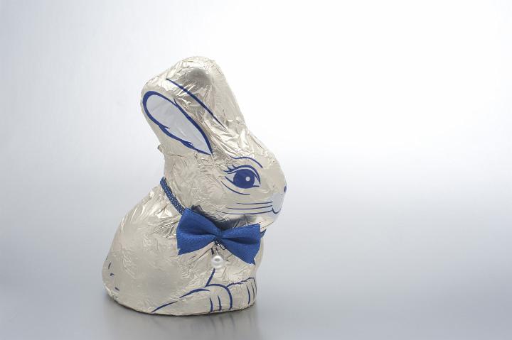 easter_bunnyrabbit.jpg - Decorative white foil wrapped chocolate Easter bunny rabbit wearing a cute bowtie on a studio background with copyspace