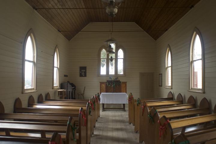 church_aisle.jpg - Aisle in rural church lined with old wooden pews leading to a simple altar