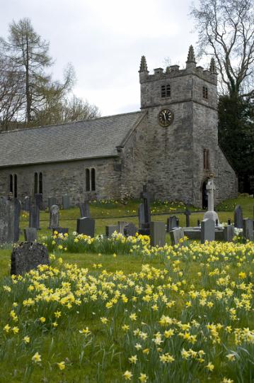 easter_church.jpg - Small stone rural Easter church with a garden filled with cheerful yellow spring daffodils