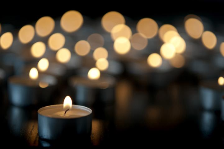 votive_candle.jpg - Burning votive candle in a church with a background bokeh from multiple additional candles creating an ethereal spiritual effect , copy space in the foreground