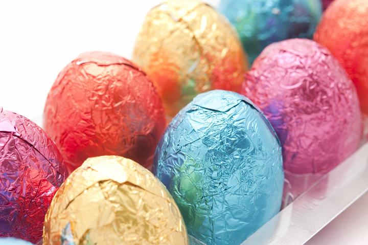 colorful_easter_eggs.jpg - Tray of colourful Easter Eggs in foil wrapping with selective focus to one blue egg