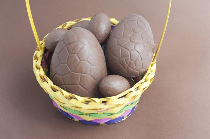 easter_chocolate_basket.jpg - Decorative basket filled with milk chocolate Easter Eggs on a brown background