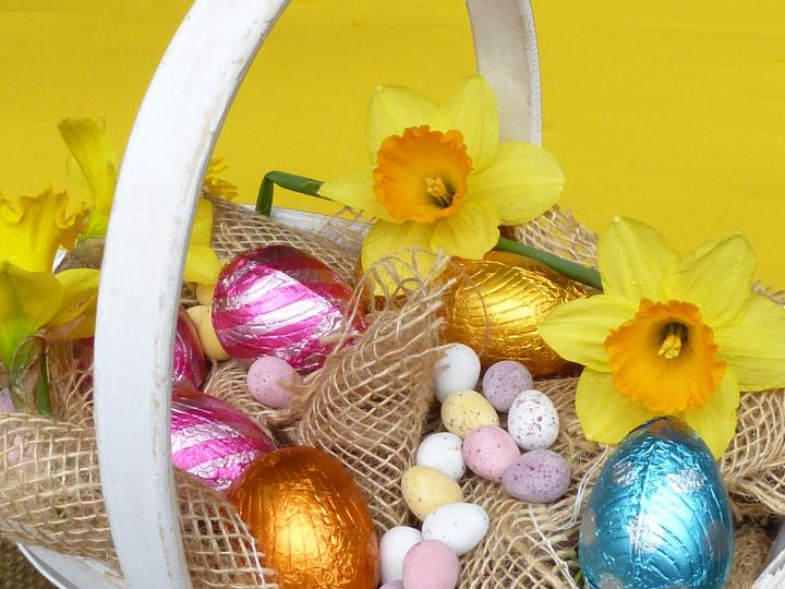 easter_decorations.jpg - Rustic Easter decorative basket with foil and sugar-coated candy eggs on hessian with yellow spring daffodils