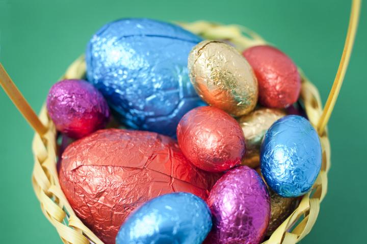 easter_egg_colection_basket.jpg - Overhead view of an Easter Egg collection of colourful variously sized foil wrapped eggs in a basket