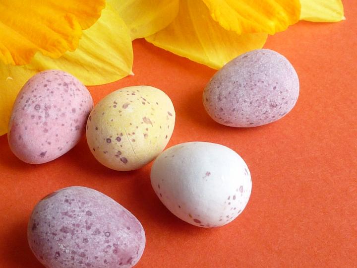 five_mini_easter_eggs.jpg - Mini sugar-coated Easter quail eggs on a textured orange background to celebrate the holiday season