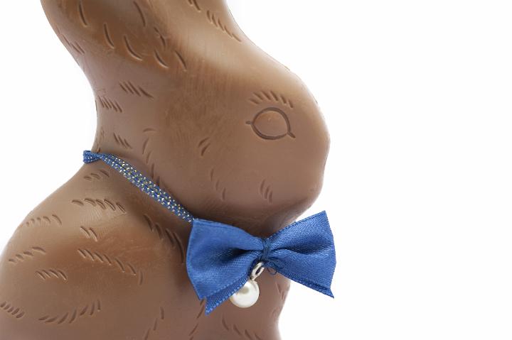 choc_easter_bunny.jpg - Closeup on white of a symbolic chocolate Easter bunny with a blue bowtie around its neck