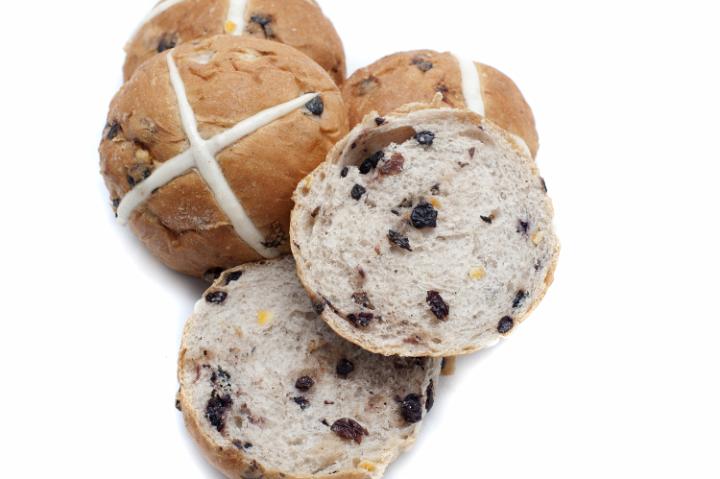 easter_currant_buns.jpg - Delicious spicy fruity Hot Cross Buns viewed from above cut through to reveal the raisins and fruit and the white pastry cross symbolic of the crucifixion