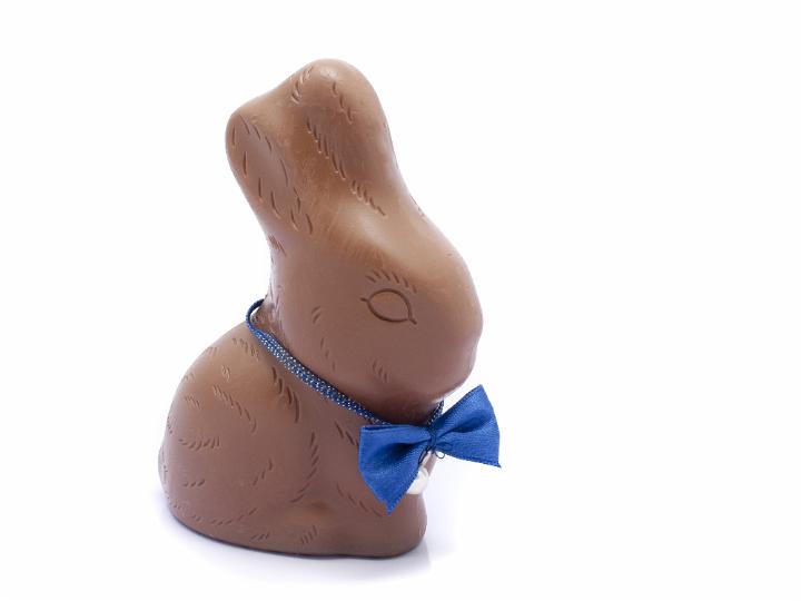 easter_chocolate_rabbit.jpg - Milk chocolate Easter rabbit egg wearing a cute blue bow tie on a white background