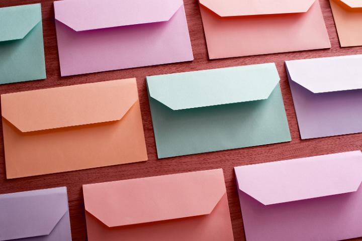 easter_colour_envelopes.jpg - Background of colorful envelopes for Easter messages arranged neatly in rows face down on wood in a full frame view